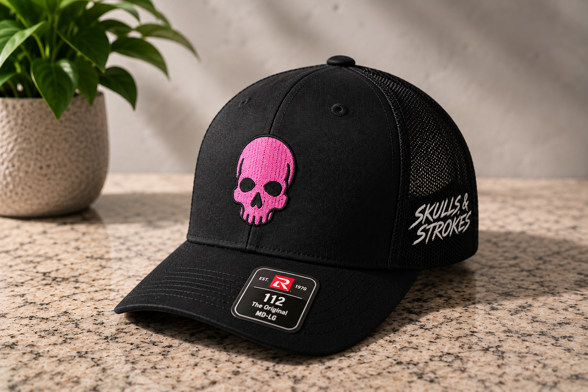 Black Skulls & Strokes Richardson 112 trucker hat with pink skull and white side embroidery
