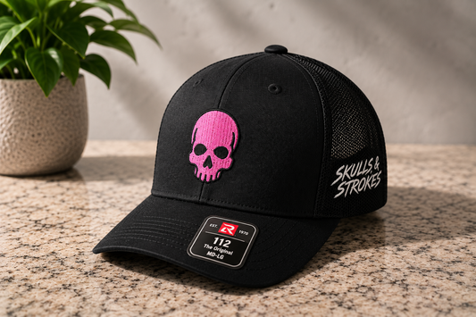 Black Skulls & Strokes Richardson 112 trucker hat with pink skull and white side embroidery
